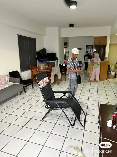 Living features: grey fabric sofa, black reclining chair, white tiled flooring, ceiling light fixture, dining table with chairs, open kitchen area, window with blinds, decorative throw pillows.