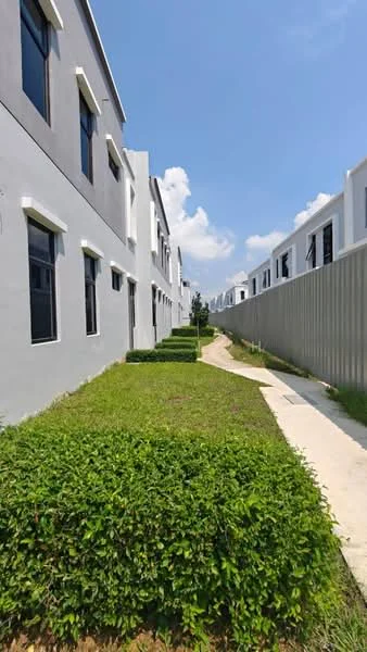 Exterior type: linked terrace house; features: grey painted facade, manicured lawn, landscaped hedges, concrete pathway, two-storey building, multiple windows, fenced perimeter, clear blue sky; style: modern.