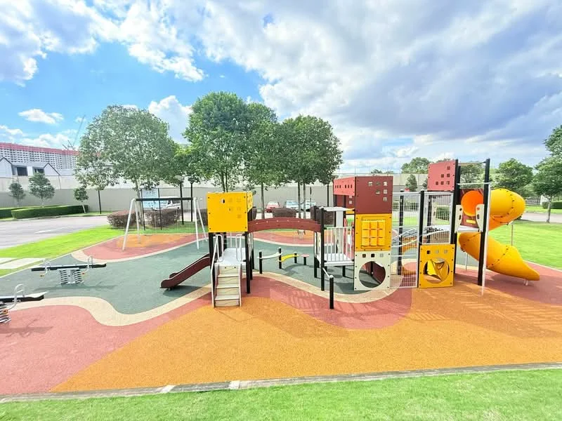 Exterior type: children's playground; features: playground equipment with slides, climbing structures, rubberized safety flooring, swings, colorful play panels, open grassy area, surrounding trees, benches for seating; style: modern.