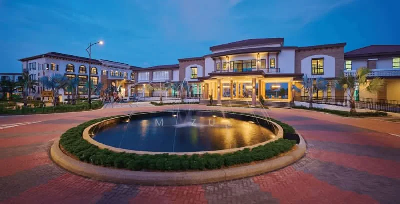 Exterior type: clubhouse; features: two-storey building, large circular water feature, landscaped garden with shrubs, paved driveway, outdoor lighting, multiple entrances, balconies on upper level, surrounding palm trees, brick paving, modern architectural design; style: modern.