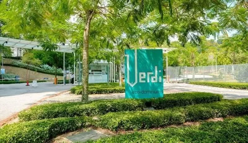 Exterior features: landscaped garden with shrubs, paved walkway, signage with the name 'Verdi eco-dominus', surrounding trees, open parking area, security booth visible; style: modern.