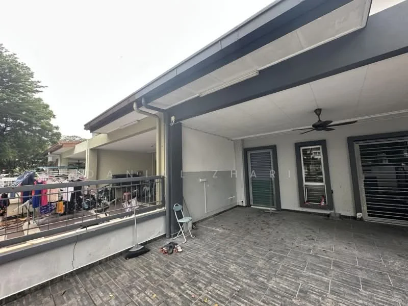 Exterior type: linked terrace house; features: covered porch area, grey painted facade, sliding glass doors, floor-to-ceiling windows, ceiling fan, stone-paved flooring, manicured lawn, outdoor seating area, laundry area visible, surrounded by greenery; style: modern.