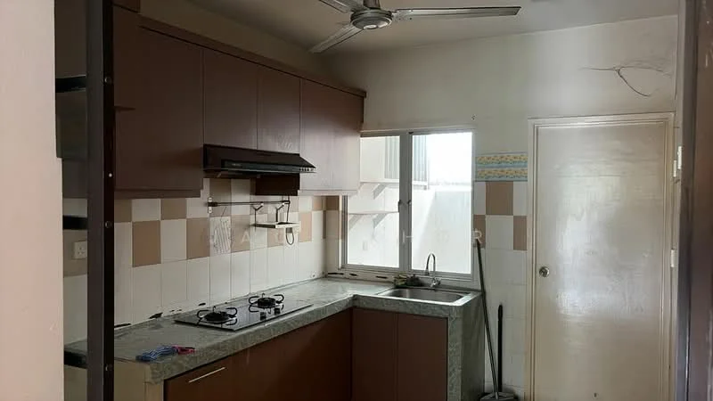 Kitchen features: brown cabinetry, grey granite countertop, stainless-steel gas hob with 4 burners, exhaust hood, white tiled backsplash, window with view to outside, single-bowl stainless-steel sink, wall-mounted faucet, ceiling fan, light switch, floor tiles, kitchen wall with cream and brown tiles.