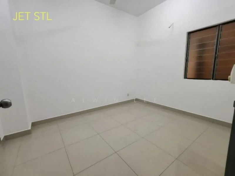 Room features: white painted walls, tile flooring, single window with horizontal bars, ceiling fan, light switch, door handle, corner wall, empty space.