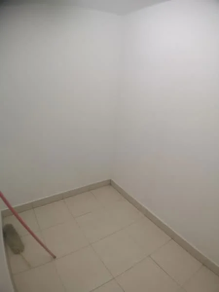 Room features: white painted walls, tile flooring, corner room, no visible windows, empty space.