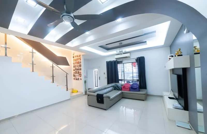 Living features: grey accent wall, white painted walls, polished tile flooring, tray ceiling with recessed lighting, 5-blade ceiling fan with integrated LED light, sofa in light grey leather, coffee table, TV console, wall-mounted TV, curtains in dark blue, decorative items on shelves, staircase with glass railing; style: modern.