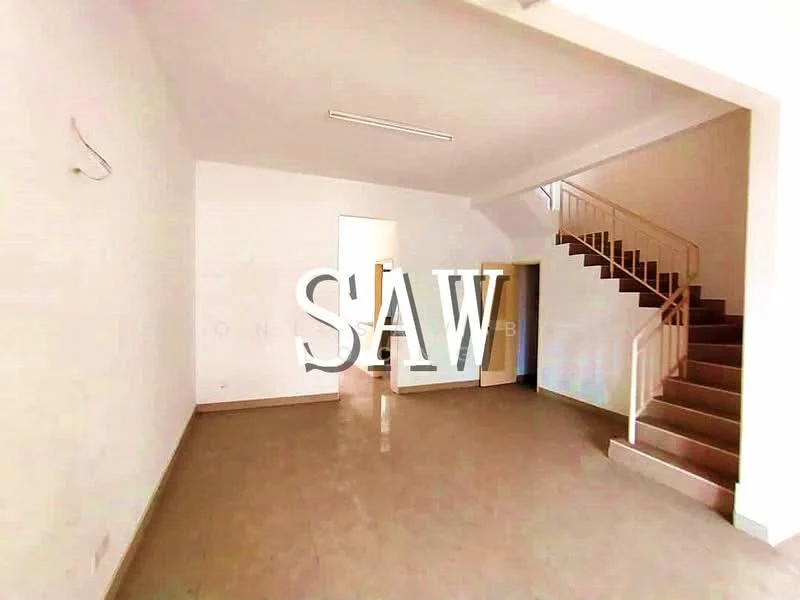 Room features: white painted walls, tile flooring, staircase with metal railing, large window allowing natural light, open layout, ceiling lights, doorway leading to another room; style: modern.