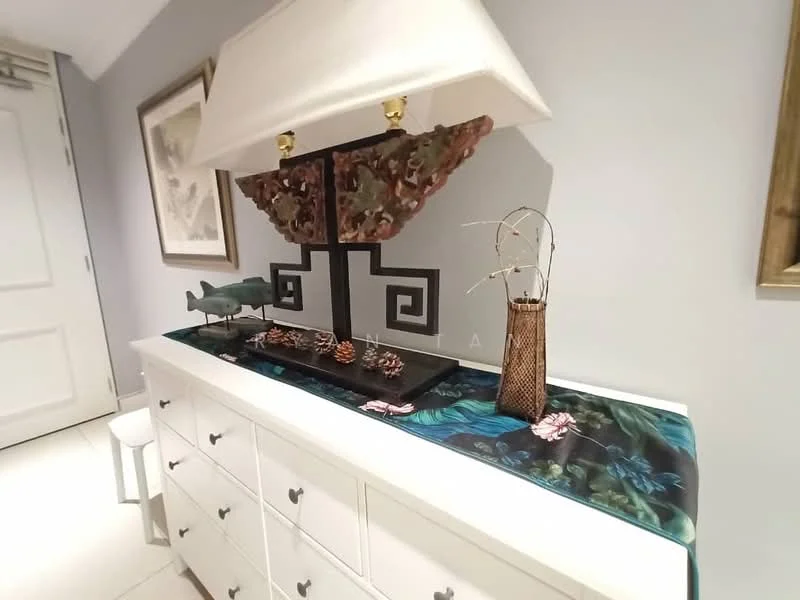Room features: white dresser with multiple drawers, decorative lamp with unique base, decorative items including a fish sculpture, pinecones as decorative elements, vase with branches, colorful table runner with tropical pattern, framed artwork on wall, neutral wall color, tile flooring; style: modern.