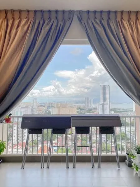 Room features: floor-to-ceiling windows, grey curtains, beige curtains, balcony with railing, city skyline view, potted plants, tile flooring, bar stools, table, natural light; style: modern; view: city.