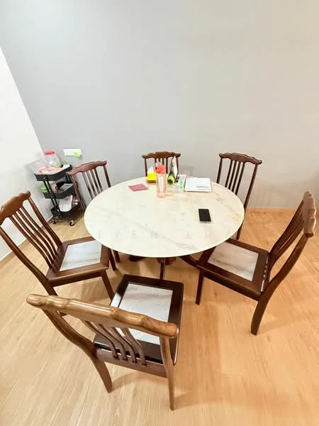 Dining features: round marble dining table, wooden dining chairs, 5 dining chairs, light wood flooring, grey painted walls, decorative items on table, small cart with kitchen items, smartphone on table; style: modern.