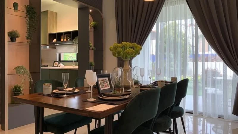 Dining features: wooden dining table, upholstered dining chairs in green, decorative vase with flowers, table setting with glasses and plates, wall-mounted shelving with plants, curtains with sheer and blackout layers, floor-to-ceiling windows, open kitchen view, green cabinetry in kitchen, light-colored flooring; style: modern; view: garden.
