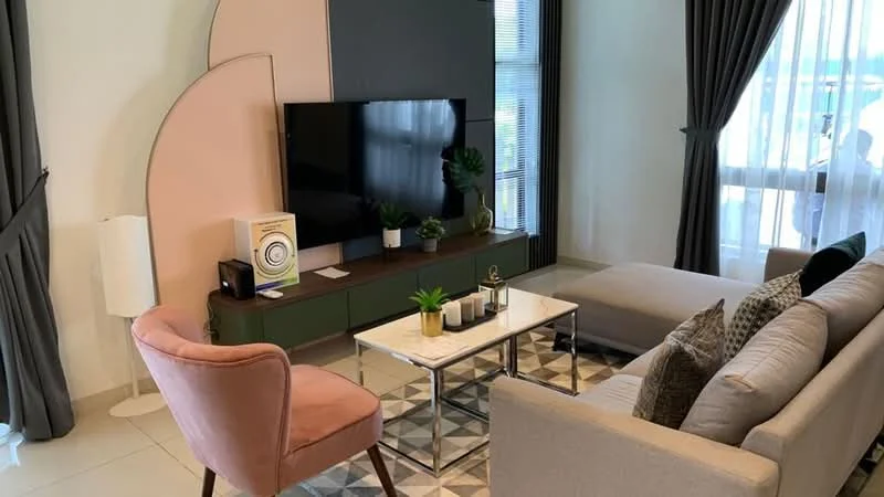 Living features: light grey fabric sofa, pink accent chair, glass coffee table, TV console with green cabinetry, wall-mounted flat-screen TV, decorative plants, curtains, geometric area rug, neutral tile flooring, wall with pink accent panel, floor lamp; style: modern.