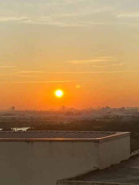 Exterior features: sunset view, city skyline, solar panels on roof.