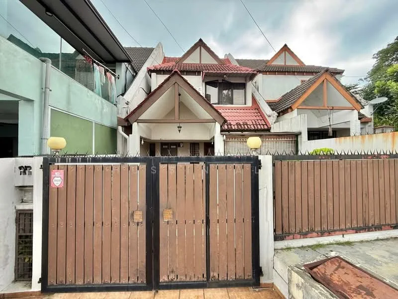 Exterior type: semi-detached house; features: brown wooden gate, white painted facade, red tiled roof, triangular gable roof, exposed brick wall, glass paneling, manicured pathway, surrounding greenery; style: traditional.