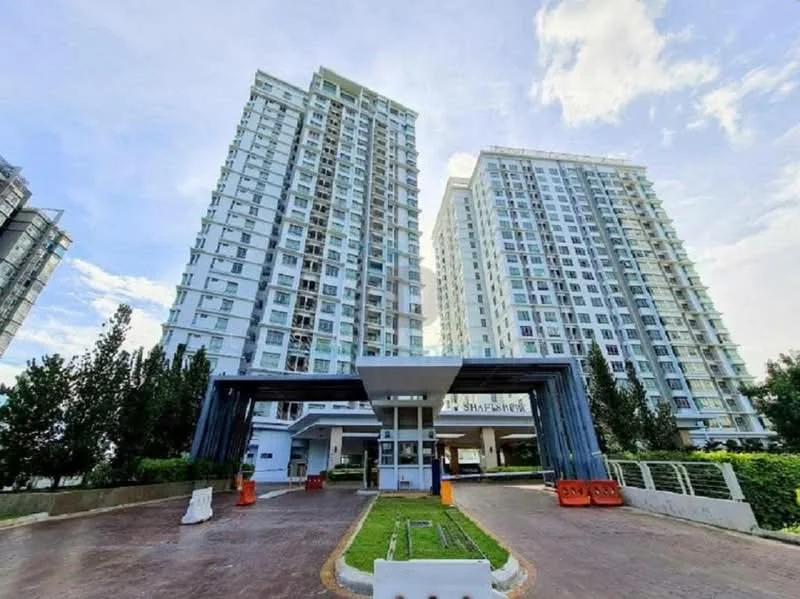 Exterior type: high-rise condominium; features: glass curtain wall, white painted facade, recessed balconies, double-volume main lobby, manicured lawn, surrounded by mature greenery, driveway with interlocking pavers; style: modern.