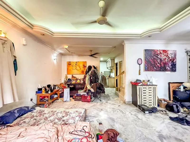 Living features: marble flooring, white painted walls, tray ceiling with recessed lighting, 5-blade ceiling fan, large window with sheer curtains, area rug with floral pattern, wooden coffee table, various items on the floor including bags and clothing, decorative artwork on the wall, staircase leading to another level; style: contemporary.