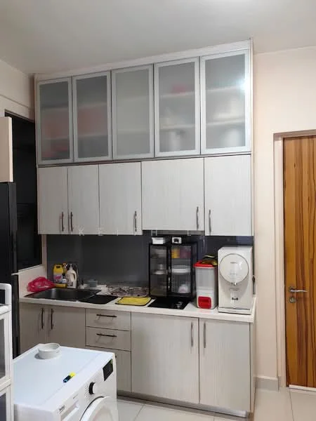 Kitchen features: white laminate cabinetry, glass-front upper cabinets, black countertop, built-in stove, kitchen sink, microwave, coffee machine, toaster, washing machine, white tiled flooring, refrigerator, wall-mounted cabinets, wooden door; style: modern.