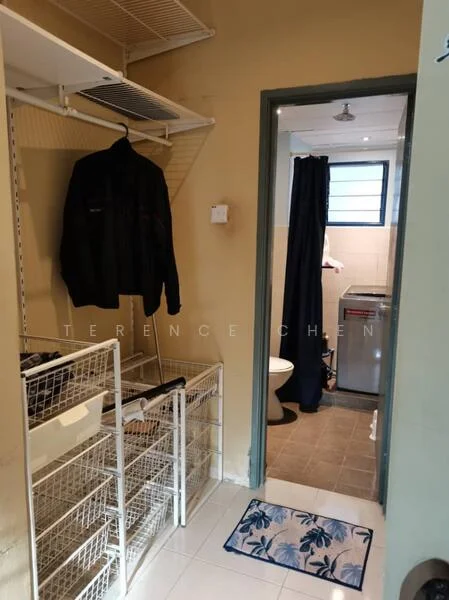 Laundry features: white wire shelving, hanging space for clothes, washing machine, tile flooring, grey painted walls, doorway to bathroom, bath mat, toilet, shower curtain.
