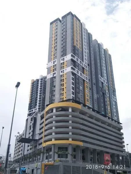Exterior type: high-rise condominium; features: glass curtain wall, yellow and grey painted facade, recessed balconies, multi-storey car park, approximately 20-storey high-rise, feature lighting at night, surrounded by urban landscape; style: modern.