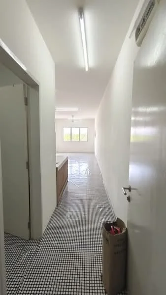Room features: white painted walls, black and white tiled flooring, fluorescent ceiling lights, two windows with natural light, open layout, doorway leading to another room, visible cabinetry, clean and minimalistic design; style: modern.