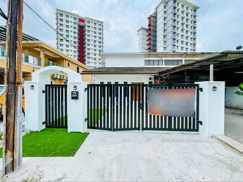 Exterior type: detached bungalow; features: black wooden gate, white painted facade, manicured lawn, paved driveway, surrounded by low fencing, two-storey residential building in background, overhead power lines, greenery around the property; style: modern.