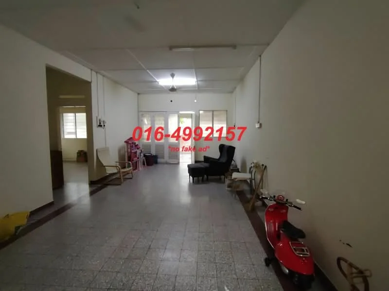 Room features: white painted walls, grey tiled flooring, ceiling fan, large windows, natural light, open layout, sitting area, wooden chair, black armchair, red scooter, yellow bag.