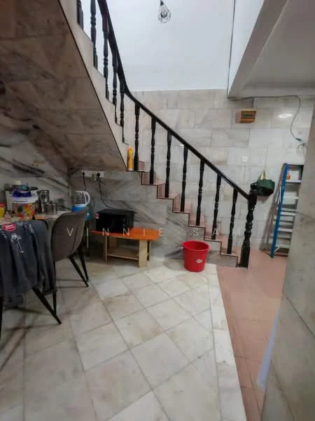 Room features: marble flooring, staircase with black wooden railing, white painted walls, exposed brick wall, wooden table, plastic chair, red plastic bucket, shelves, various items on shelves; style: modern.
