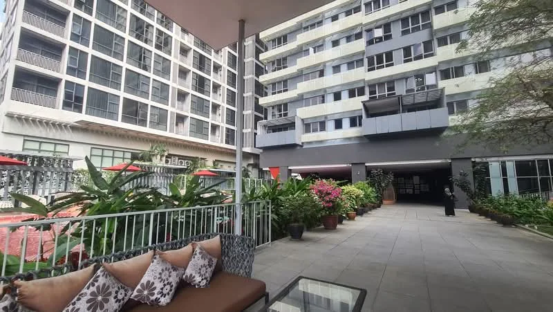 Exterior type: high-rise condominium; features: landscaped garden with flowering plants, paved walkway, outdoor seating area with cushions, multiple-storey building, entrance to parking area, surrounding greenery, balconies on upper floors, decorative outdoor lighting; style: modern.