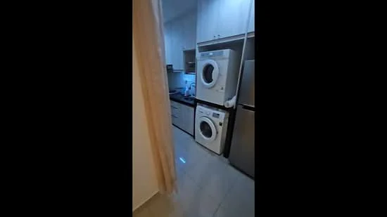 Laundry features: front-load washing machine, front-load dryer, stainless-steel refrigerator, white cabinetry, grey countertop, tile flooring, light-colored walls, recessed lighting; style: modern.