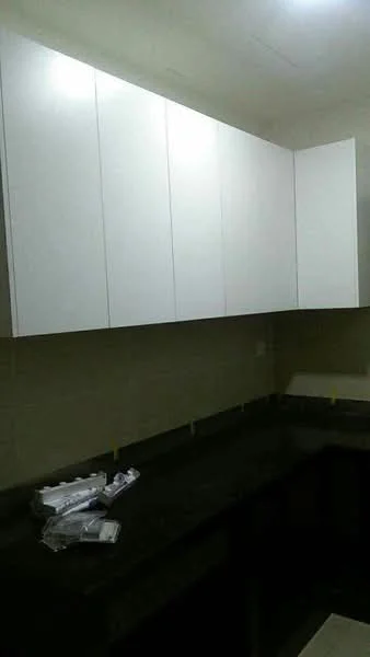 Kitchen features: white cabinetry, black granite countertop, wall-mounted cabinets, under-cabinet lighting, neutral wall tiles, kitchen installation materials visible; style: modern.