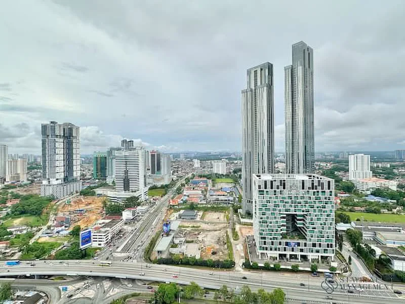 Exterior type: high-rise condominium; features: glass curtain wall, recessed balconies, surrounded by mature greenery, urban context with skyline view, multiple high-rise buildings, highway visible in foreground; style: modern.