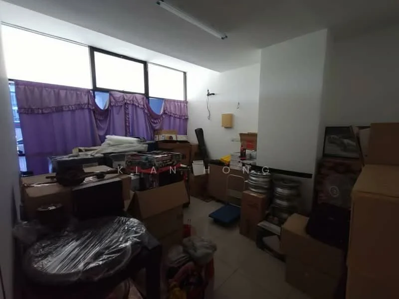 Room features: white painted walls, tile flooring, large windows with purple curtains, cardboard boxes, stacked items, plastic wrap on furniture, various storage items, cluttered layout.