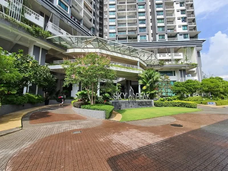 Exterior type: high-rise condominium; features: glass entrance canopy, landscaped garden with shrubs, paved walkway, water feature, signage with 'SKY DREAM RESIDENCES', tropical landscaping with palm trees, multiple storeys visible, modern facade with balconies, driveway leading to entrance; style: modern.