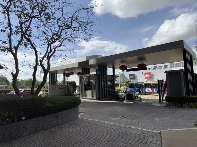 Exterior type: main entrance gate; features: guard house at entrance, modern architectural design, grey stone cladding, black vertical fins, red lanterns, paved driveway, landscaped greenery, surrounded by trees, visible security intercom, perimeter fence; style: modern.