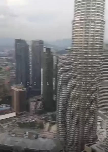 Exterior type: high-rise condominium; features: glass curtain wall, modern architectural design, surrounded by city skyline, multiple high-rise buildings, urban landscape, visible rooftops, city view, cloudy sky; style: modern.