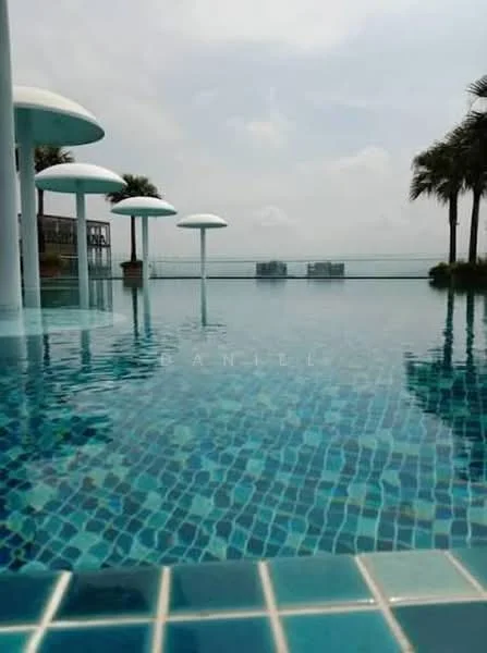 Exterior type: swimming pool deck; features: infinity pool, tiled pool flooring with mosaic pattern, palm trees surrounding the pool, umbrella shades over poolside, glass railing, view of city skyline in background; style: modern.