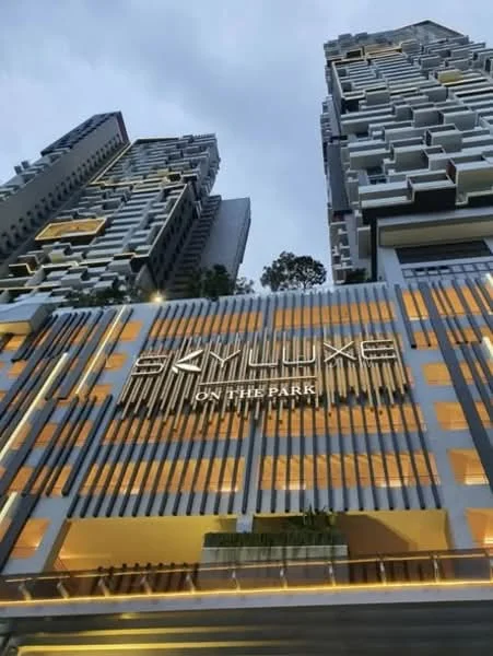 Exterior type: high-rise condominium; features: glass curtain wall, projecting balconies, feature lighting at night, concrete facade, multiple storeys, landscaped entrance; style: modern.