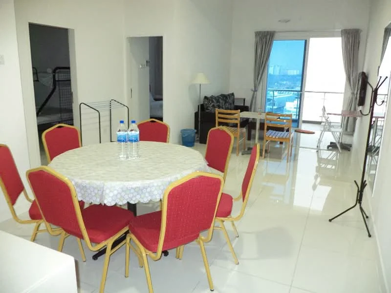Dining features: round dining table with white tablecloth, 8 red upholstered dining chairs, white tiled flooring, large window with city view, curtains, floor lamp, water bottles on table; style: modern; view: city. Living features: sofa in dark fabric, coffee table, dining area visible, large window with city view, curtains; style: modern; view: city.