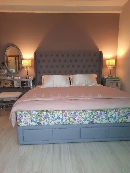Bedroom features: king-size bed with upholstered headboard, bedding in light colors, decorative floral bed skirt, two bedside tables, two table lamps with warm light, framed mirror on the wall, wooden flooring, painted accent wall in taupe, light-colored throw blanket, decorative chair, wall-mounted artwork; style: modern.