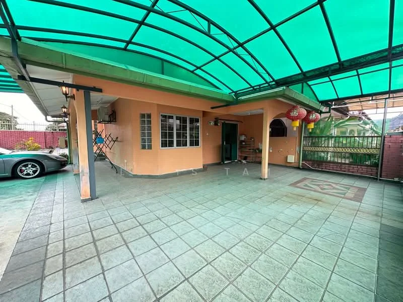 Exterior type: semi-detached house; features: green polycarbonate roof, paved flooring, car porch, exterior wall in peach color, windows with grills, decorative lanterns, fenced perimeter, outdoor space with seating area; style: modern.
