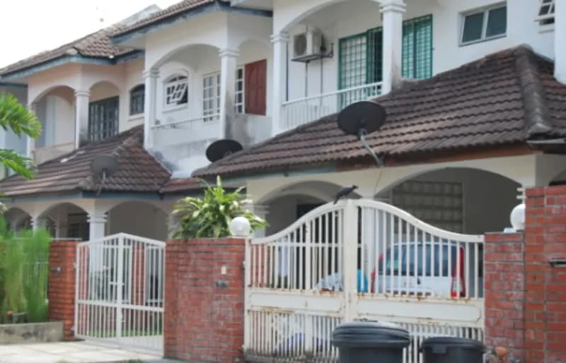 Exterior type: linked terrace house; features: red brick facade, white painted facade, pitched tile roof, front garden with greenery, gated entrance, two car porch, visible air conditioning unit, satellite dishes on roof, decorative columns, balconies with railings; style: modern.