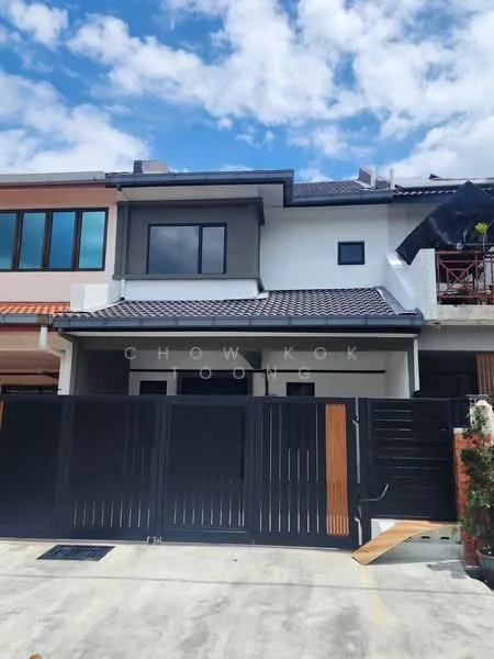 Exterior type: linked terrace house; features: white painted facade, grey accent wall, pitched tile roof, black metal gate, wooden accents on gate, two-storey structure, front porch area, manicured landscaping, clear blue sky, construction scaffolding visible, driveway with concrete surface; style: modern.