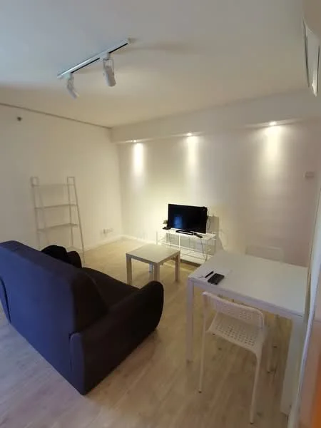 Living features: 3-seater fabric sofa in dark grey, white coffee table, white dining table, 4 white dining chairs, wall-mounted TV, track lighting, light wood flooring, white painted walls, open shelving unit; style: modern.