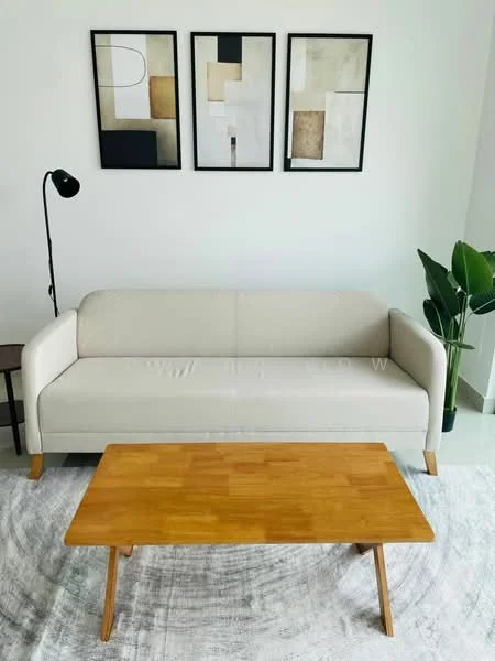 Living features: beige fabric sofa, wooden coffee table, area rug with geometric pattern, floor lamp, framed abstract artwork on walls, potted plant, white painted walls, light-colored flooring; style: modern.