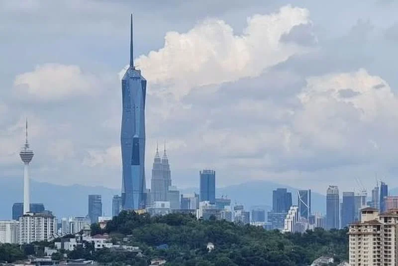 Exterior features: city skyline, tall skyscrapers, cloudy sky, green hill in foreground, Petronas Twin Towers, KL Tower, Merdeka 118; style: modern.