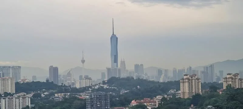 Exterior features: city skyline, tall skyscrapers, distant mountains, urban landscape, mixed-use buildings, greenery in foreground; style: modern.
