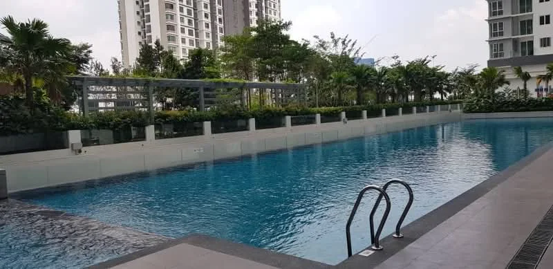 Exterior type: swimming pool deck; features: infinity pool, pool deck with loungers, landscaped garden with greenery, surrounding palm trees, modern pool railing, tile flooring around pool, water feature, high-rise condominium in background; style: modern.