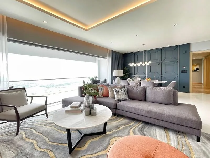Living features: large sectional sofa in grey, coffee table with marble top, area rug with abstract pattern, floor-to-ceiling windows, city view, recessed LED downlights, pendant light fixture, decorative cushions in various colors, plant in ceramic pot, wall-mounted TV, accent wall with geometric paneling, side chair with wooden frame; style: modern; view: city.