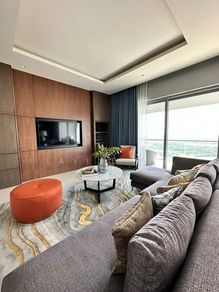 Living features: grey fabric sectional sofa, orange round ottoman, glass coffee table, area rug with abstract pattern, wall-mounted TV, wood panel feature wall, floor-to-ceiling windows, curtains, decorative cushions, vase with flowers; style: modern; view: city.