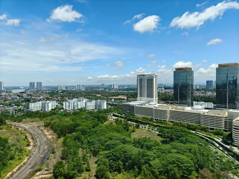 Exterior type: high-rise condominium; features: city skyline view, surrounded by greenery, urban landscape, multiple high-rise buildings, open sky, clear visibility, mixed-use development, adjacent to railway, manicured landscaping; style: modern.